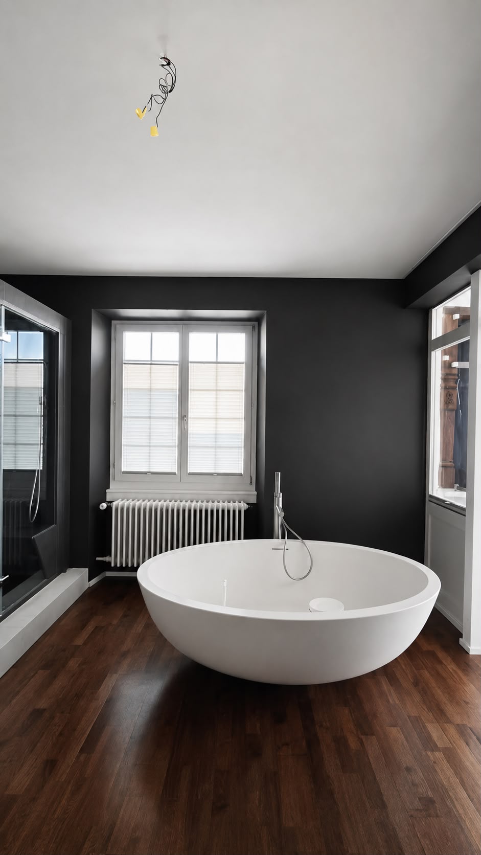 Renoviertes Badezimmer mit anthrazitfarbener Wand und freistehender Badewanne