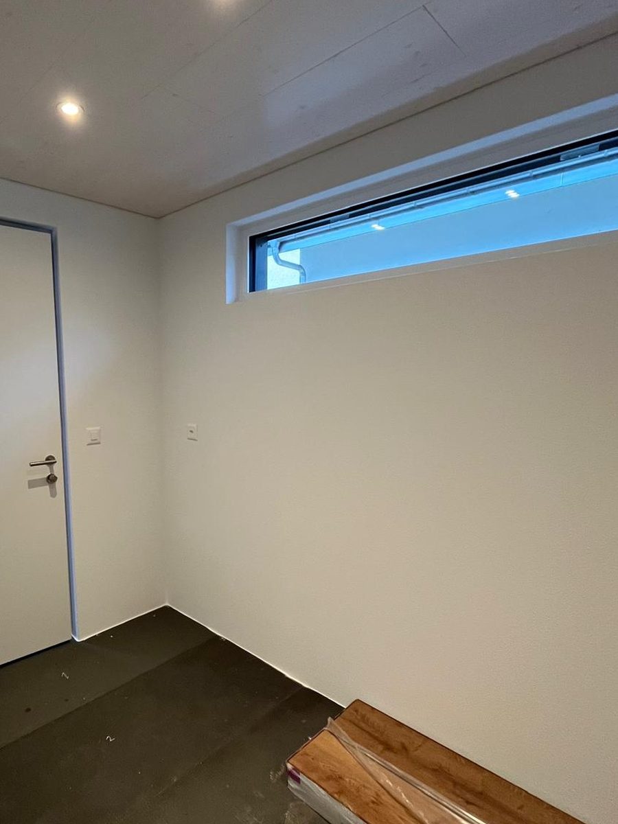 Derselbe Eingangsbereich fertig gespachtelt und gestrichen, mit geschlossener Decke und sauber gefasstem Türrahmen