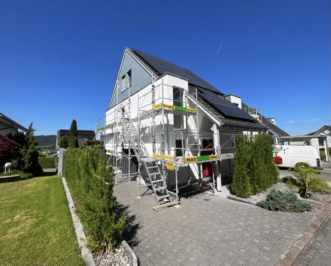 GL Maler mit Amore bei Fassadenarbeiten an einem eingerüsteten Einfamilienhaus