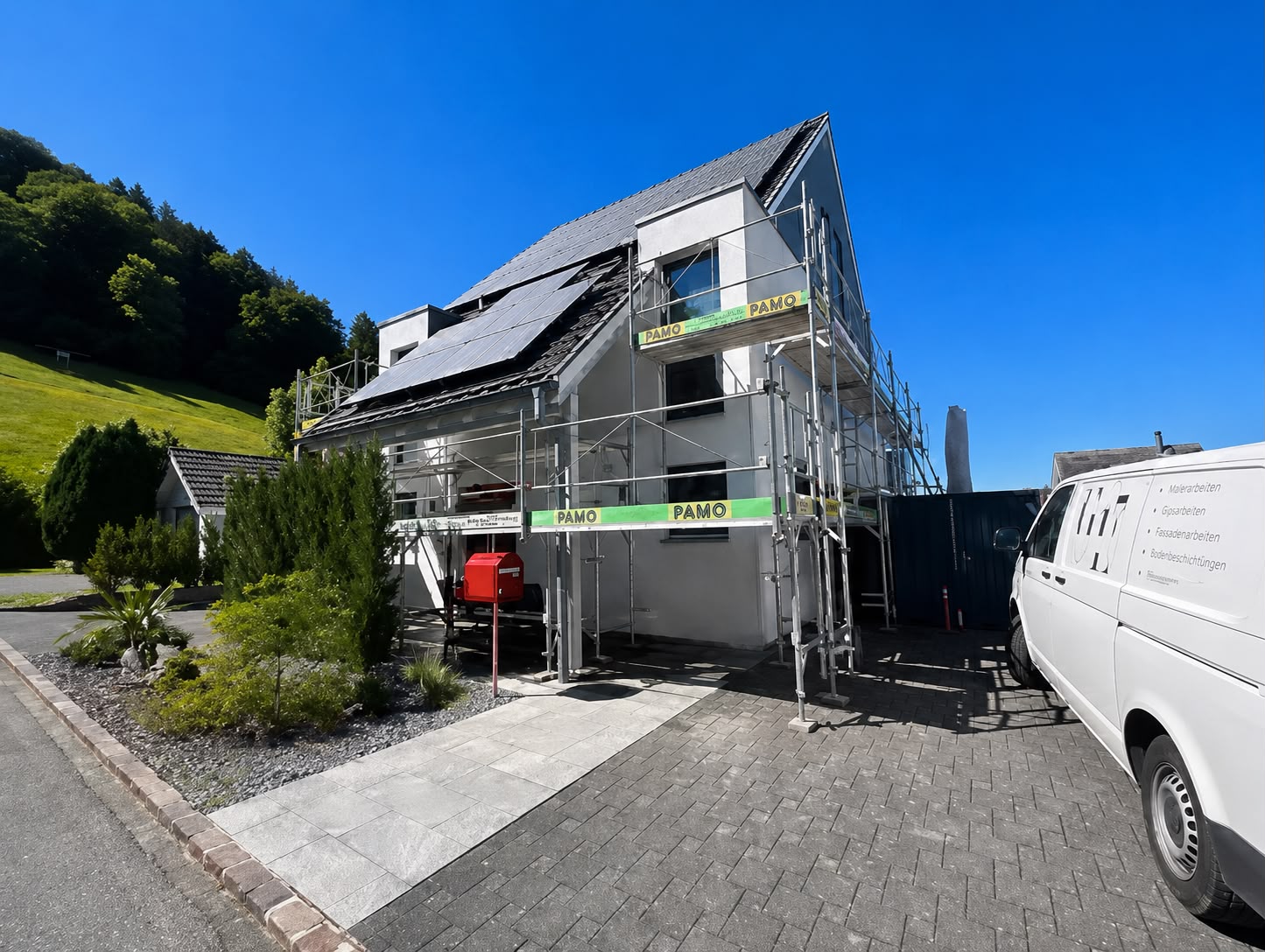 Eingerüstetes Einfamilienhaus von der Gartenseite