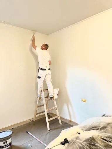 Gianluca Lanno bei präzisen Malerarbeiten an einer Innenwand